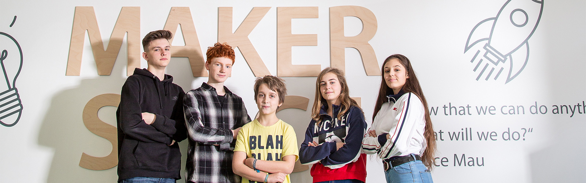 Schüler vor Makerspace Schriftzug