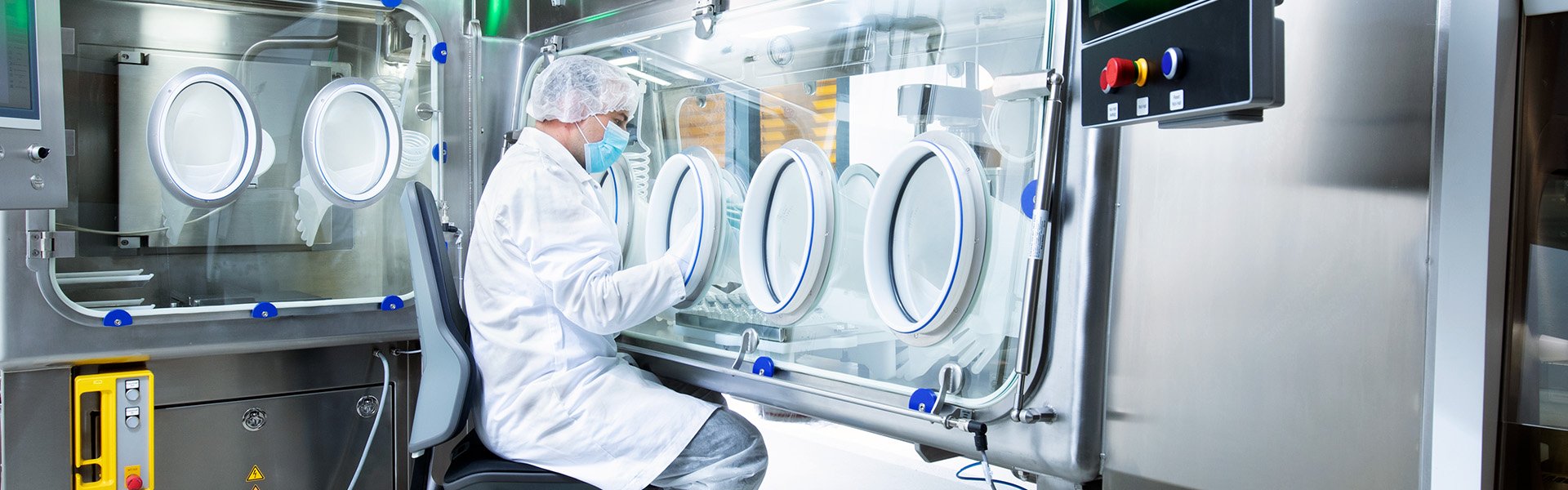 Person arbeitet an pharmazeutischem Isolator