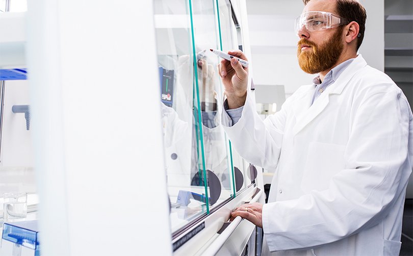 Person überprüft Glasfront eines Laborgeräts