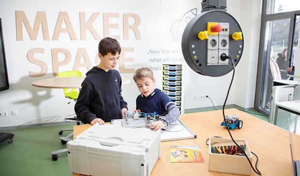 Students collaborating with technical tools in a makerspace setting