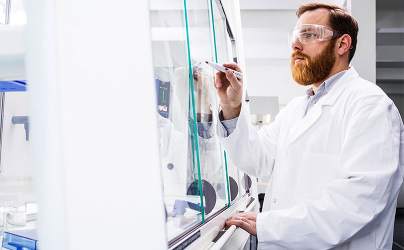 Lab assistant working in fume hood with inclined sash