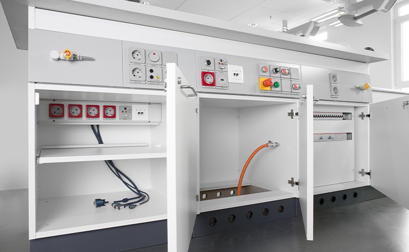 Laboratory supply module with open cabinets and visible connections for power, gas and data