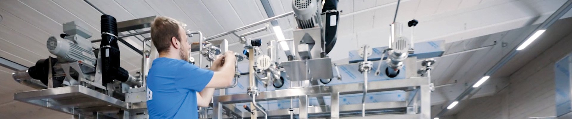 Techniker prüft eine Verpackungsmaschine von oben.