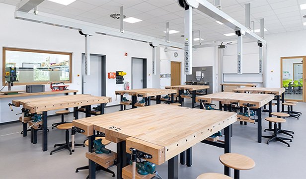 Workshop room with large wooden tables and technical equipment