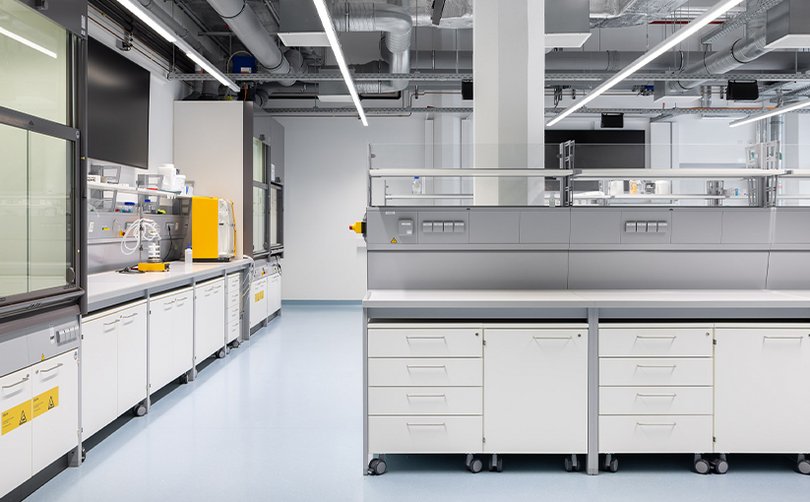 Moderner Laborraum mit Arbeitsinseln und Geräten.
