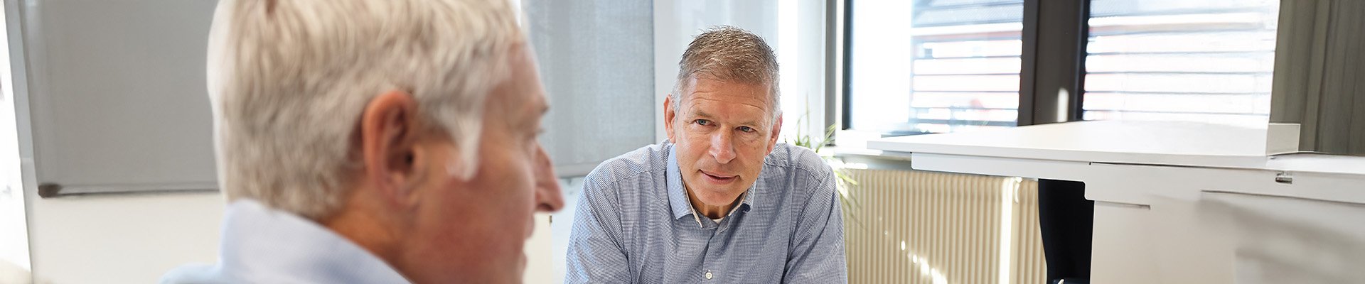 Zwei Männer im Gespräch in einem Büro