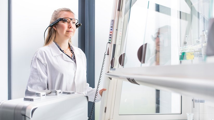 Laborabzug mit arbeitender Person im Fokus