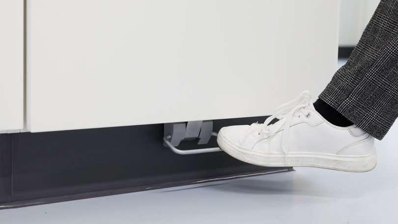 Base cabinet with foot pedal