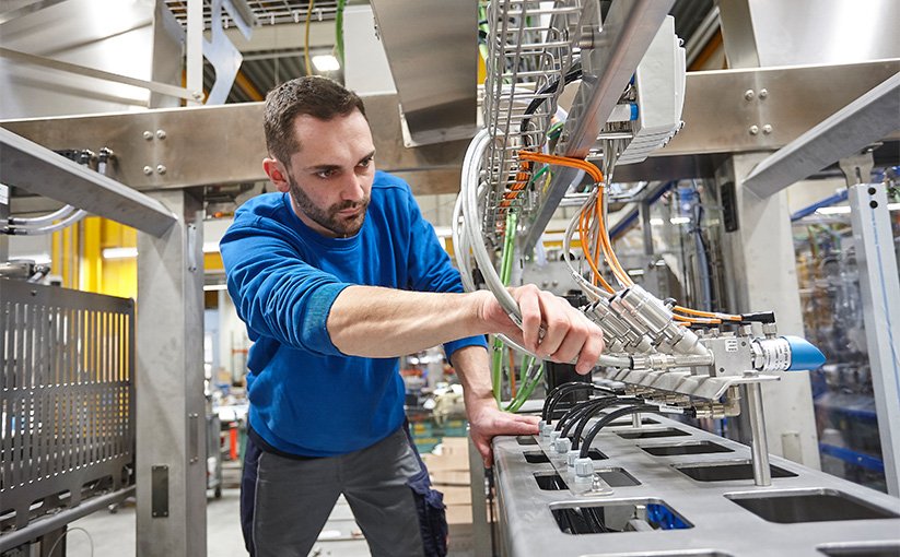 Technician inspects a machine during operation
