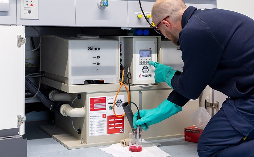 A technician in protective clothing is carrying out maintenance work