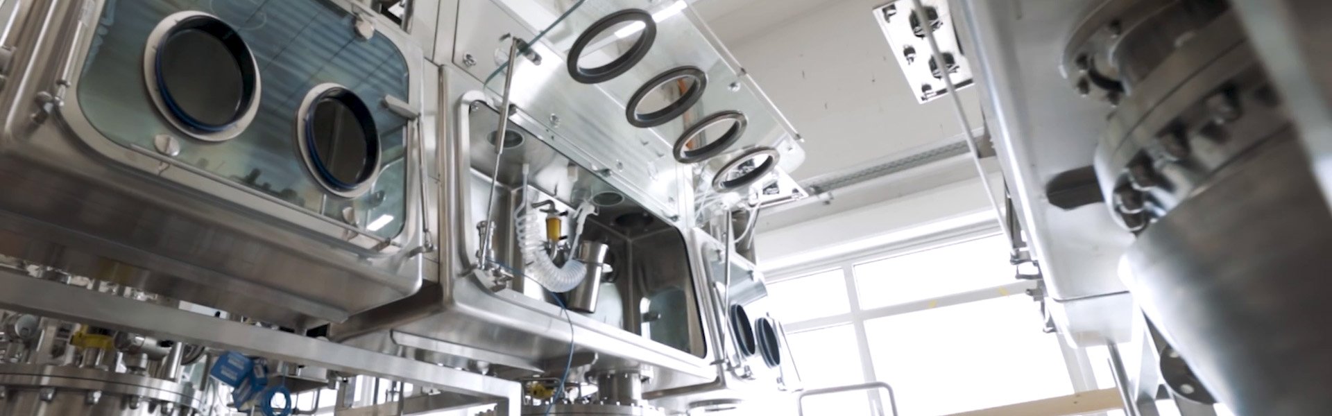 Detailaufnahme einer technischen Anlage mit mehreren Sichtfenstern und Edelstahlkomponenten.