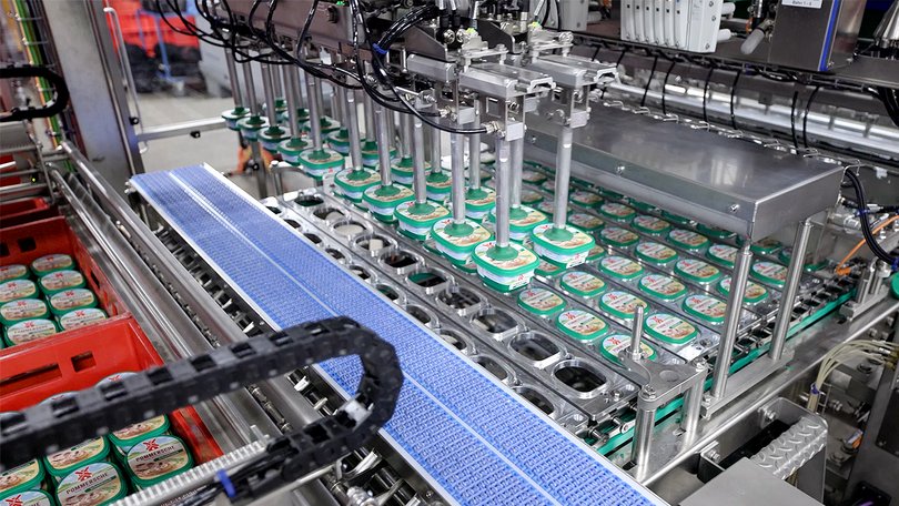 Conveyor belt with buckets in ongoing production