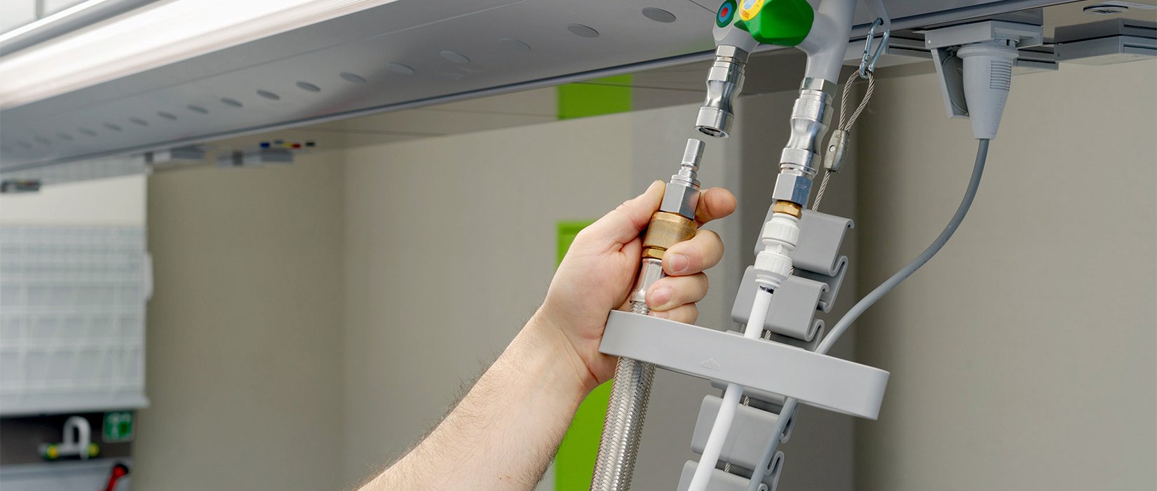 Person connects hoses to ceiling-mounted media system