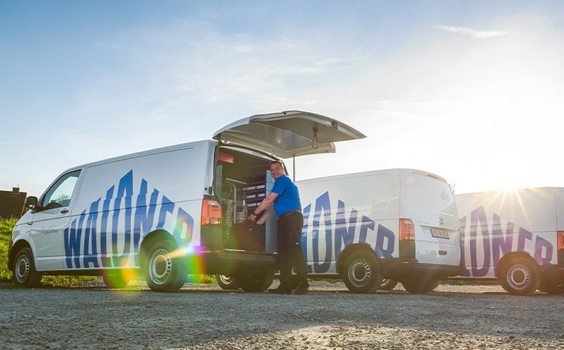 Servicefahrzeuge mit Waldner-Logo vor Gebäude