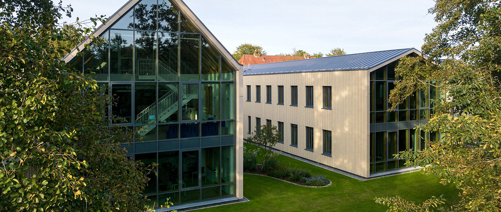 Modern school building surrounded by trees and sunlight