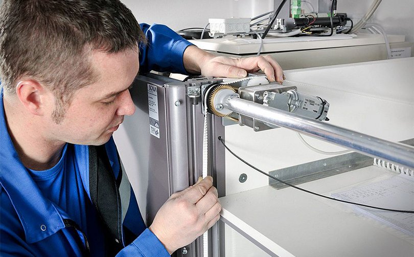 Person überprüft technischen Anschluss unter Abzug