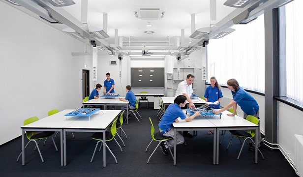 Students and instructor working on experiments in a bright learning space