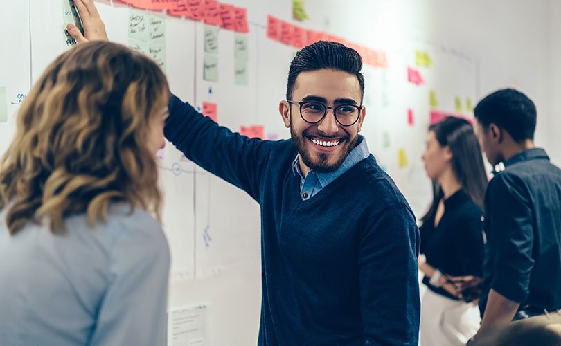 Kollegen vor Wand mit Post-its