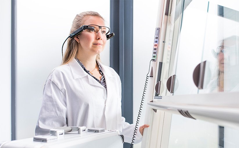 Person wearing glasses working on laboratory equipment