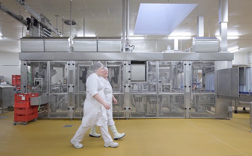 Rügenwalder Mühle employees in front of a longitudinal runner machine
