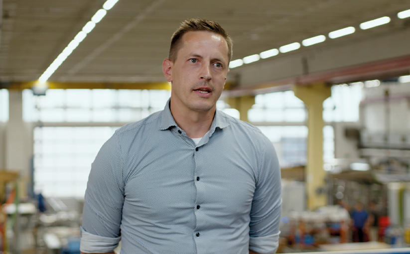 Portrait photograph of an employee in a production hall