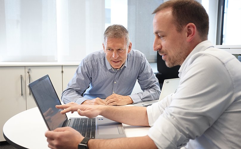 Zwei Personen im Gespräch in einem Laborumfeld, Fokus auf individuelle Beratung.