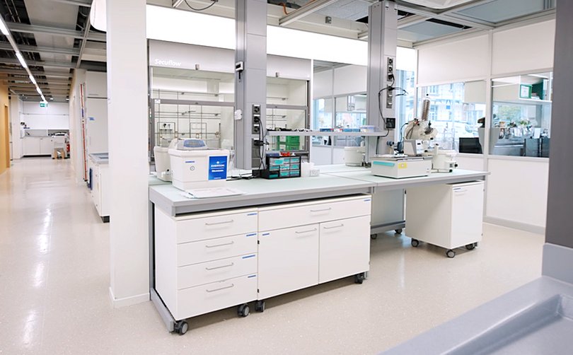 Moderner Laborarbeitsplatz mit Tisch und Geräten.