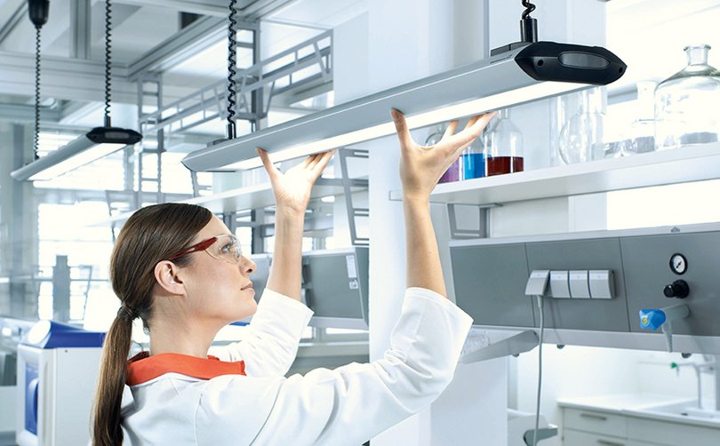 Person prüft Beleuchtung in modernem Raum