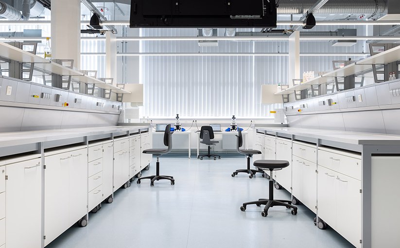 Laboratory room with workbenches and stools.