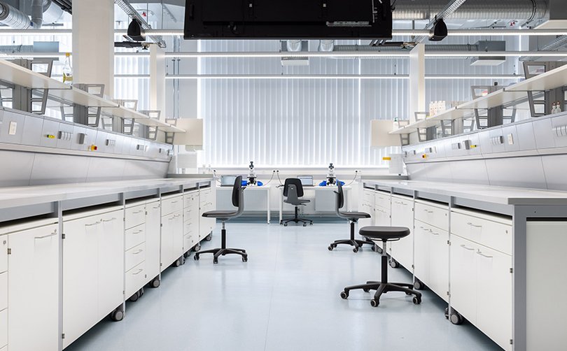 Laborraum mit Arbeitszeilen und Hockern.