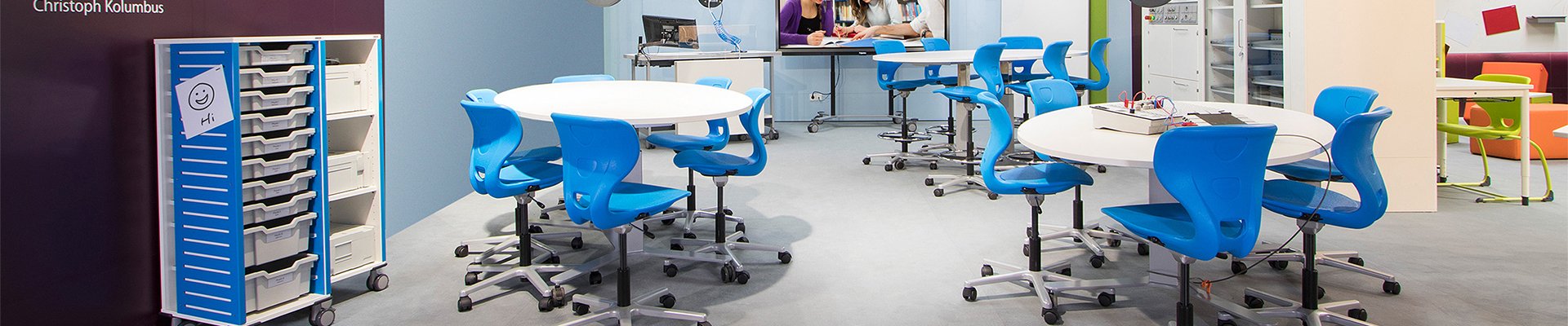 Modern classroom with blue chairs and modular tables