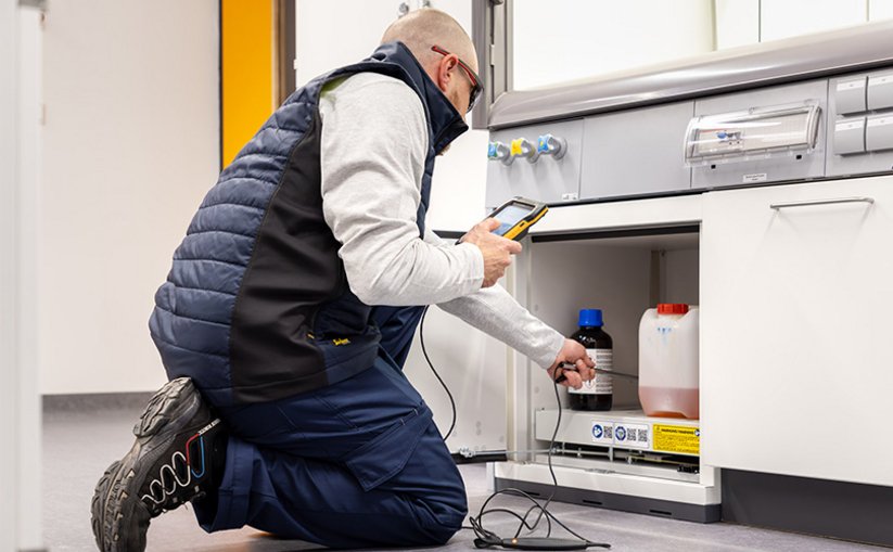 Man installing a base cabinet in a laboratory