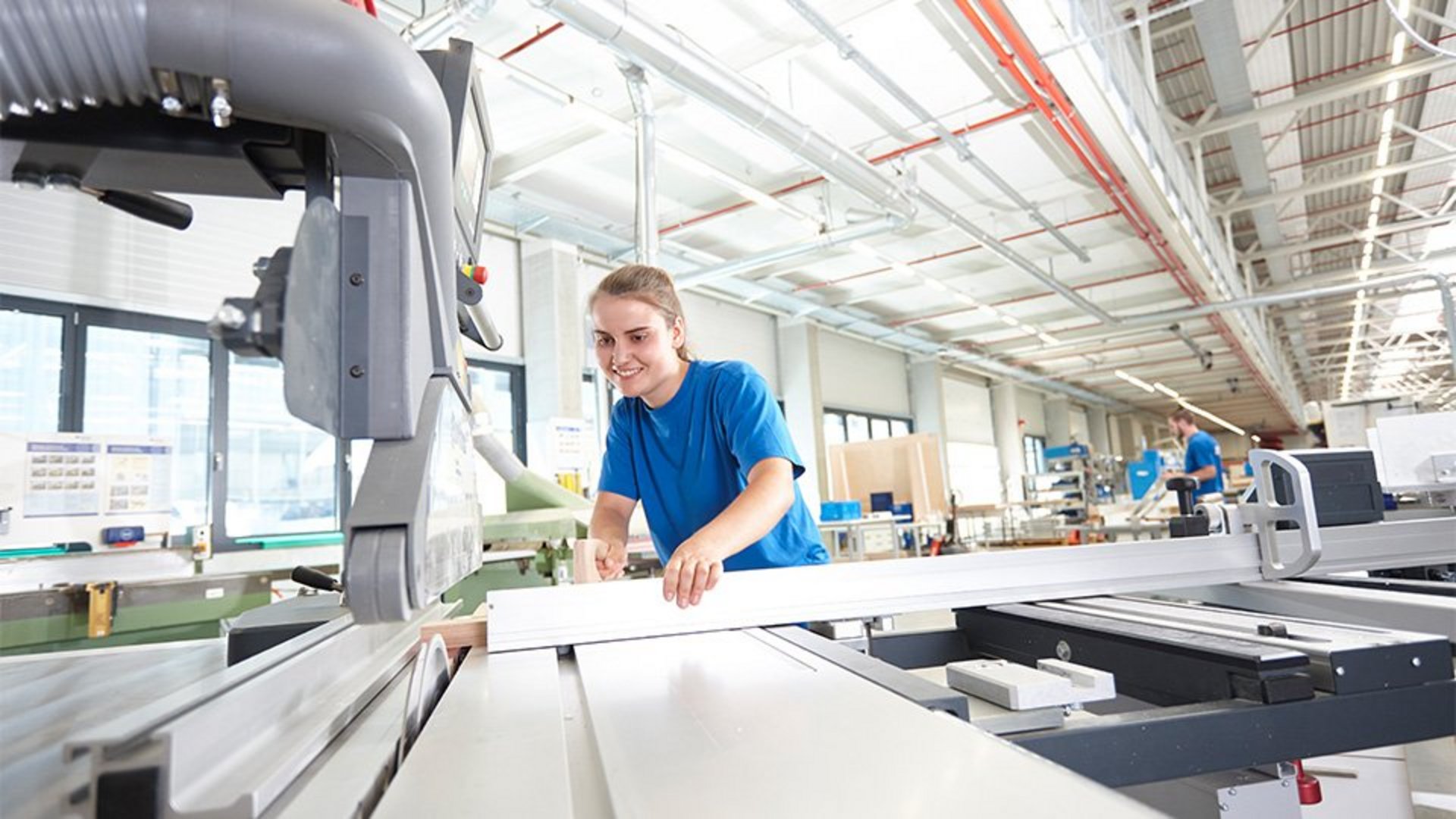 Frau arbeitet an Maschine in einer Werkstatt