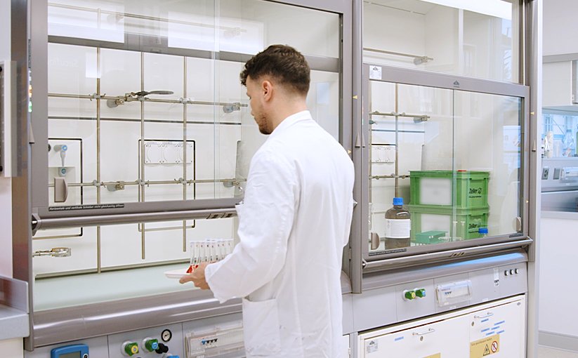 Laboratory technician working with samples at the fume hood.