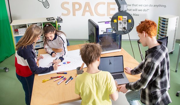 Students engaging in hands-on experiments at a modular makerspace table