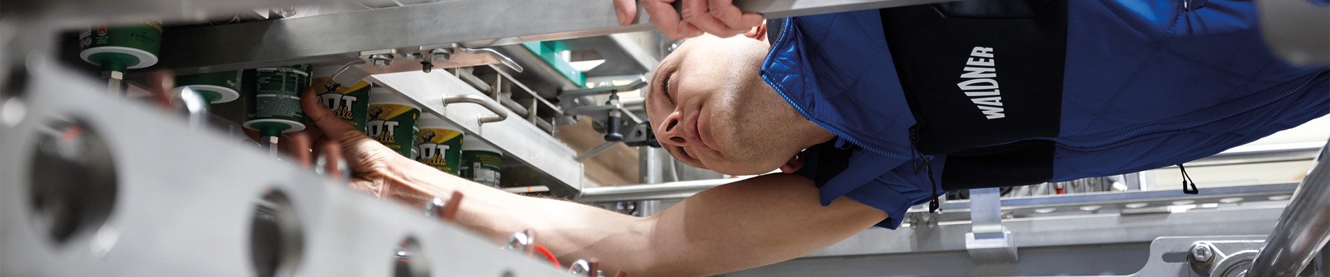 Techniker führt Reparaturarbeiten im Inneren einer komplexen Maschine durch