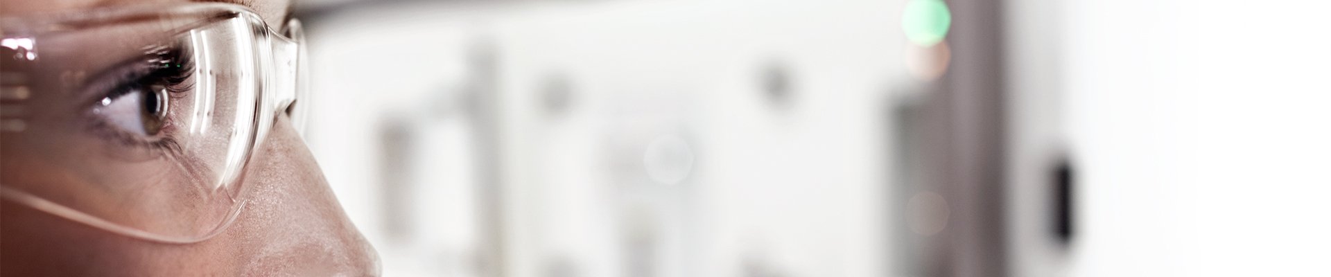 Person mit Schutzbrille arbeitet an Laborgerät